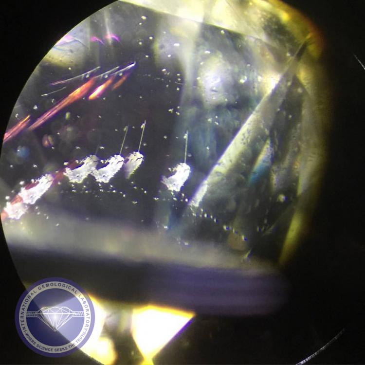 Drill-hole reaching dark inclusion and a Pink-to-purple flash effect in a Laser-drilled diamond.  - Photo by: Naveed Zafar G.G., AJP (GIA).