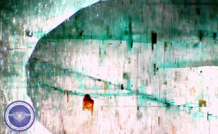 Color concentration is visible under magnification in a Dyed Beryl, color is added, to resemble the color of Emerald - Photo by: Naveed Zafar G.G., AJ