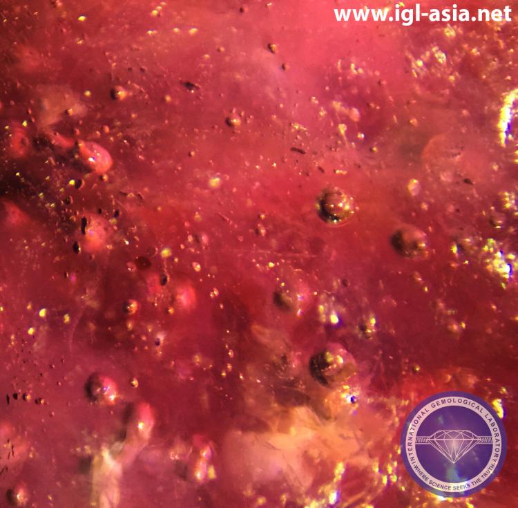 Round and Elongated Gas Bubble in a Natural Ruby treated by Lead-Glass Fill.   Photo by: Naveed Zafar G.G., AJP (GIA).